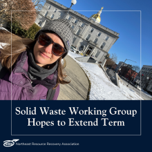 Image of smiling woman in purple coat in front of the NH state capitol